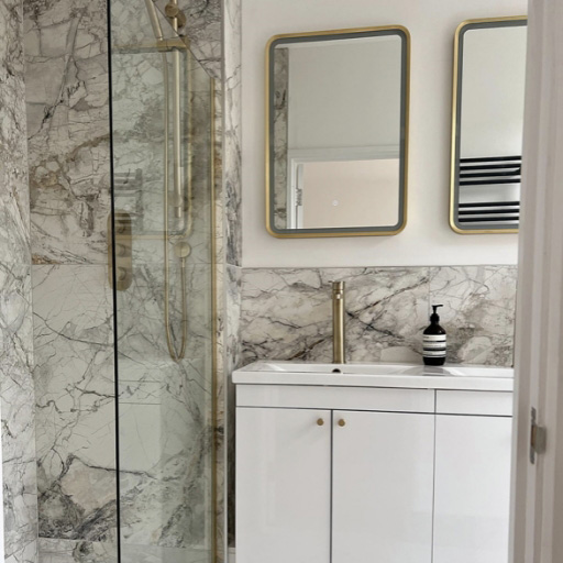 Brushed brass taps and details with marble tiles